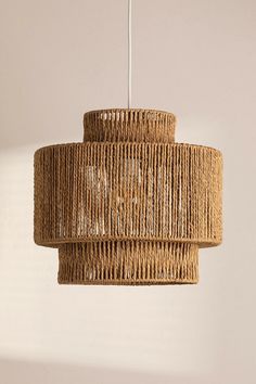 a woven light fixture hanging from a ceiling