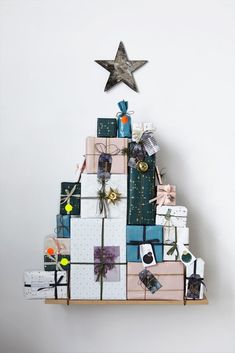 a christmas tree made out of boxes and wrapped presents with a star on the top