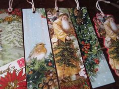 four christmas bookmarks with santa claus and birds hanging from strings on a wooden table