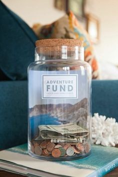 a glass jar filled with coins sitting on top of a table next to a couch