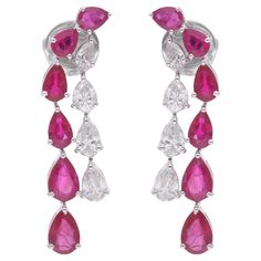 Embrace the allure of elegance with these Pear Shape Ruby Gemstone Dangle Earrings, adorned with diamonds and meticulously crafted in 14 karat white gold. Each earring features a captivating pear-shaped ruby gemstone, renowned for its rich red hue and timeless beauty, exuding sophistication and grace. Item Code :- SEE-11825W (14k) Gross Wt. :- 4.89 gm 14k Solid White Gold Wt. :- 3.81 gm Natural Diamond Wt. :- 1.38 Ct. ( AVERAGE DIAMOND CLARITY SI1-SI2 & COLOR H-I ) Ruby Wt. :- 4.01 Ct. Earrings White Gold Drop Earrings, Burmese Ruby, Diamond Dangle Earrings, Statement Earring, White Gold Earrings, White Gold Jewelry, Ruby Gemstone, Lovely Jewellery, Diamond Drop Earrings