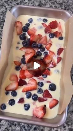 a pan filled with strawberries and blueberries on top of a counter