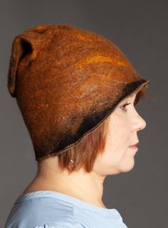 Black and Coppery Golden Felted Hat  This cute felted hat is very light weight, durable and warm. The natural quality of felt gives it some water resistance The hat is made of 100% merino wool and is decorated with silk thread. It is typically 58 - 60cm in diameter.  It hugs the ears and fits very snug.  Made to order in whatever color and size you need. Adjustable Felt Hat For Winter, Curved Brim Felt Hat, Felt Hat With Curved Brim, Curved Brim Felt Hat, One Size Fits Most, Felt Hat With Curved Brim, One Size Fits Most, Winter Brown Felt Hat, Brown Felt Hat For Winter, One Size Fits Most, One Size Brown Alpaca Hat, Handmade Wool Brown Hats