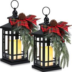 two black lanterns decorated with pine cones and red plaid bows are sitting next to each other