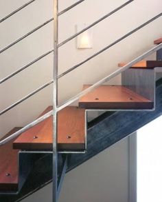 a set of stairs with wooden treads and metal handrail