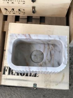 a marble sink sitting inside of a box on top of a floor next to other boxes