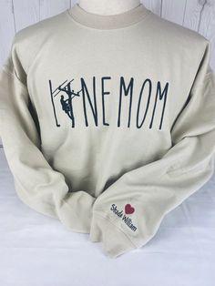 New Lineman Mom Shirt, designed for proud moms who want to show off their love for their hard working Son personalized with your Son's name on the sleeve.  Comfortable and versatile, this crewneck is perfect for any casual occasion. It is made from high-quality materials that are soft and breathable to keep you feeling comfortable all day long.  Available in a variety of sizes, this shirt makes a great addition to any mom's wardrobe. Whether you're running errands or spending time with family, t Lineman Shirts, Spending Time With Family, Mom Wardrobe, Sleeve Embroidery, Time With Family, Proud Mom, Hard Working, Womens Clothing Sizes, Mom Shirt