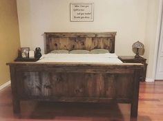 a bed with wooden headboard and foot board on hard wood flooring in a bedroom