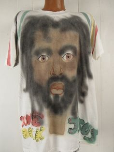 "Vintage 1990s primitive outsider or folk art style t shirt. Made of white cotton with 2 sided air brushed graphics. Has large portrait on the front and symbol on back. Reads: Come back Jesus Love Life. Signed: Loren A. Evans 91. Size extra large. Actual measurements are: 46\" around the chest 46\" around the waist 22\" shoulder seam to shoulder seam 32\" overall length In excellent condition." Casual Cotton T-shirt With Artwork, Summer Streetwear Top Hand Printed, Casual White T-shirt With Artwork, Hand Printed T-shirt For Summer Streetwear, Hippie Style White Short Sleeve T-shirt, Vintage Style Hand Dyed Short Sleeve T-shirt, Hippie Style Screen Print T-shirt For Festival, Summer Streetwear Hand Printed T-shirt, Vintage Cotton T-shirt For Festival