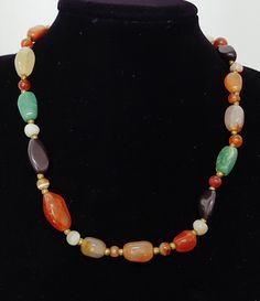 Vintage 60s Mixed Gemstone Necklace of Natural Mixed Hand Polished Seni Precious Beaded Stones Necklace with brass spacer beads and a brass barrel closure. Features 35 assorted natural irregular polished and round polished gemstones including agates, onyx, carnelian, quartz, and chrysoprase. Georgeous earthy coloured gem assortment in a lovely length to compliment any outfit. Quality stones in a classically balanced bead composition. Era: 70's Condition: Excellent Composition: Asorted polished g Vintage Beaded Necklace With Stones As Gift, Vintage Beaded Necklace With Stones For Gift, Vintage Natural Stones For Jewelry Making, Vintage Gemstone Beaded Necklaces For Jewelry Making, Vintage Natural Stones Beaded Necklaces, Vintage Beaded Necklaces With Natural Stones, Vintage Necklaces With Oval Natural Stones, Vintage Gemstone Beads For Jewelry Making, Vintage Necklace With Oval Gemstone Beads