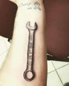 a tattoo with a wrench on the arm