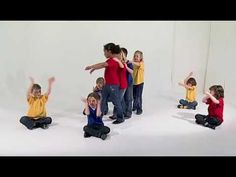 a group of children sitting on the ground with their arms in the air