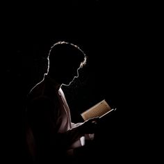 a man reading a book in the dark