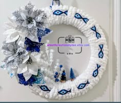 a white wreath with blue and silver decorations