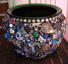 a vase with many different types of buttons and charms on the inside, sitting on a table