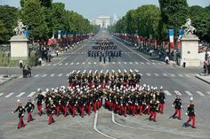 a group of people that are standing in the street with some marching equipment on them