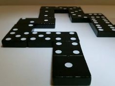 black and white dominos arranged in the shape of a cross on a table top