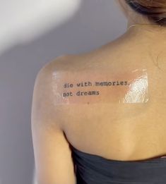 the back of a woman's shoulder with an inscription on it that reads, die with memories not dreams