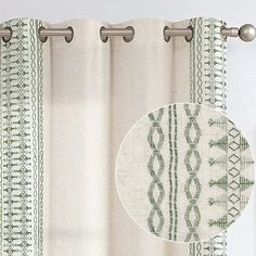 the curtain is hanging in front of a window with an embroidered design on it, along with a round metal rod