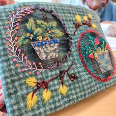 a woman sitting at a table in front of a laptop computer with embroidered designs on it