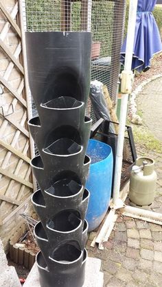 a stack of black pots sitting on top of a cement block