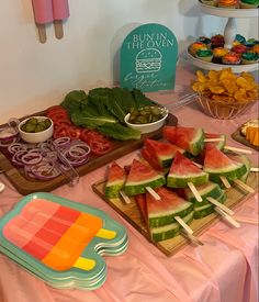 watermelon slices, onions, and other vegetables are arranged on a buffet table