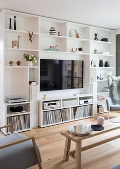 a living room filled with furniture and a flat screen tv on top of a wall