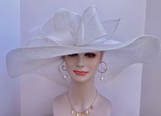 "The oversized brim adorned with a jumbo sinamay bow in and feathers  design characterizes this horse racing event hat made of natural straw. The large brim creates a statement piece, and the sinamay jumbo bow  and netting adds a touch of whimsy and feminine elegance. Crafted from straw, it exudes a light and airy feel, making it a stylish and comfortable choice for a day at the races. The hat combines the classic appeal of a wide brim with the playful charm of a jumbo sinamay bow and netting , White Party Hat With Feather Trim, White Feather Trim Party Hat, White Summer Hat With Feather Trim, Elegant Costume Hat With Feather Trim And Curved Brim, Elegant White Hat With Feather Trim, Elegant White Feathered Costume Hat, Elegant White Mini Hats With Feather Trim, Elegant White Mini Hat With Feather Trim, Chic White Top Hat For Church