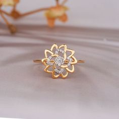 a diamond ring sitting on top of a white table next to a flower shaped branch