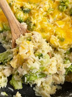 rice and broccoli are mixed together in a skillet with a wooden spoon