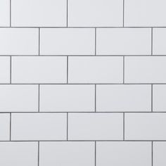 a white tiled wall with black grouting