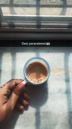 a person holding a cup of coffee in their left hand with the words desi paracetomolole on it