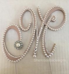 a pair of scissors with pearls attached to the side of it on a white surface