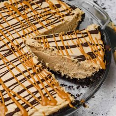 a chocolate cheesecake with caramel drizzled on top and one slice missing