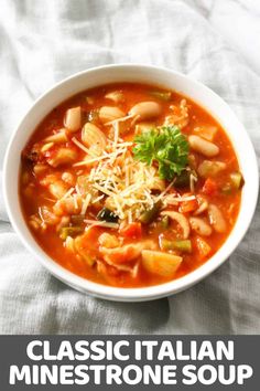 a white bowl filled with pasta and vegetable soup on top of a marble countertop