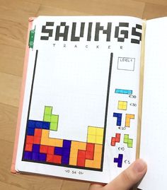 someone is holding up a book with an image of squares and numbers on the pages