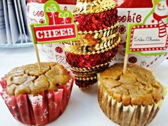 three cupcakes are sitting next to each other on a table with christmas decorations