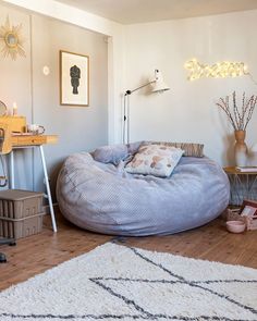 a large bean bag chair sitting on top of a wooden floor next to a table