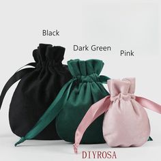 three bags with different colors and designs on the front, one in black, one in pink