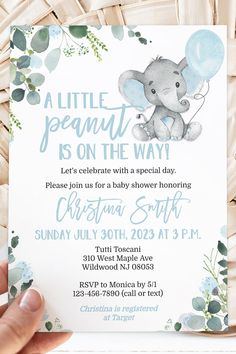 a baby elephant is on the way for its first birthday party with blue flowers and greenery