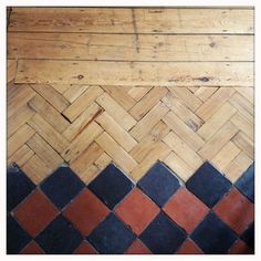 the floor is made out of wood and has black, red and white tiles on it