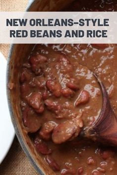 a pot full of beans and rice with a wooden spoon in the bowl next to it