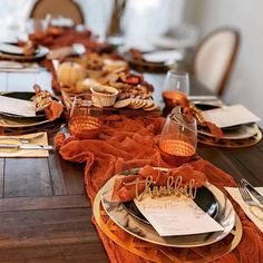 a table set for thanksgiving dinner with plates and napkins