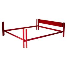 a red metal bed frame with two posts on each side and no headboard or foot board