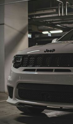 the front end of a white jeep parked in a garage