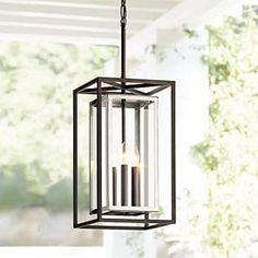 a light fixture hanging from the ceiling with two candles in it's caged holder