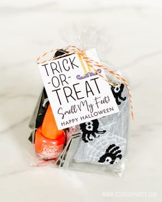 a trick or treat bag with an orange and black candy in it on a marble surface