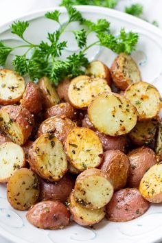 a white plate topped with potatoes and parsley