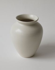 a white vase sitting on top of a table