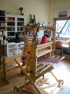 an old weaving machine is sitting in the middle of a room with lots of clutter